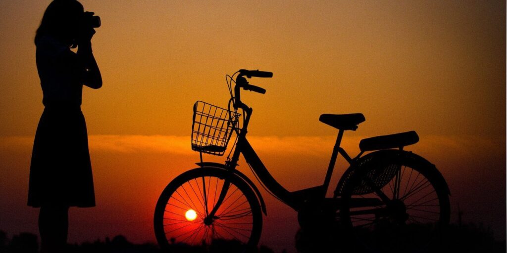 Nő, kerékpár, naplemente